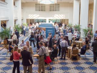 Meeting attendees gathered in a spacious sunlit hall.